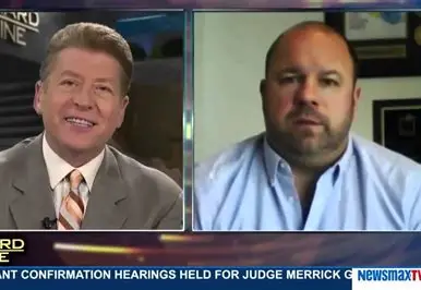 Split-screen Newsmax TV still of a host and Ken Wisnefski during a remote interview